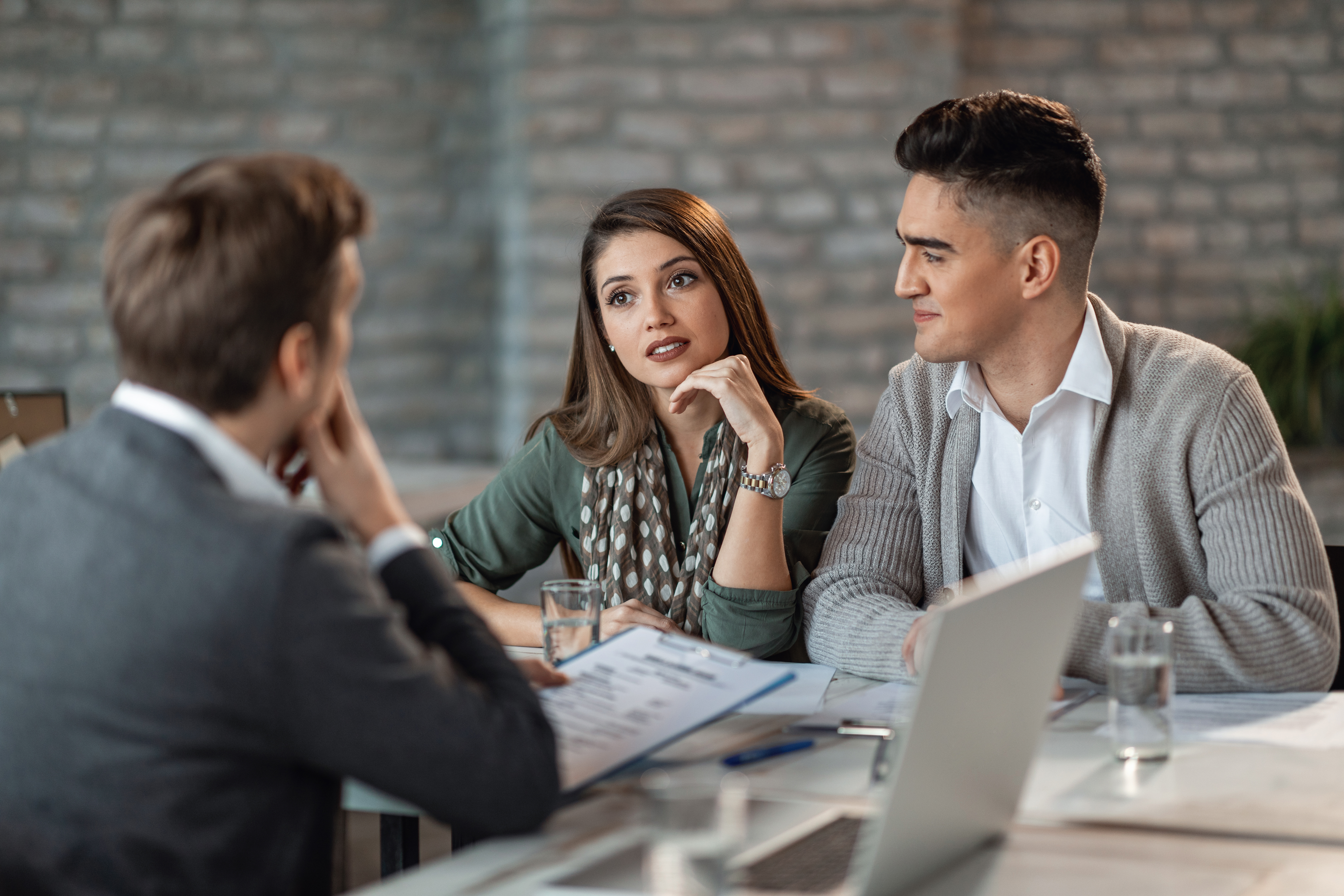 Young couple consulting with their insurance agent in the office.